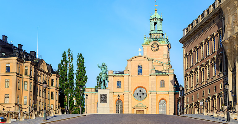 Widok na Pałac Królewski i plac Stortorget z kolorowymi kamienicami i katedrą Storkyrkan w Gamla Stan, Sztokholm.