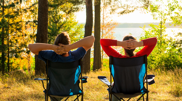 Ein Paar im Sommerurlaub auf Camping Stühlen