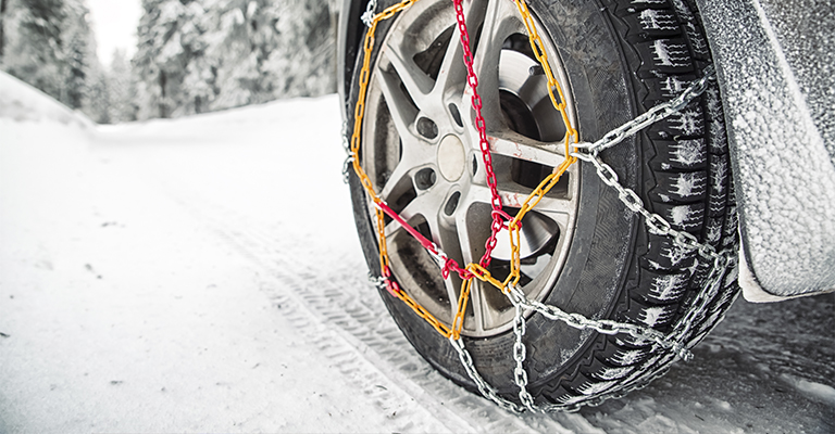 Łańcuchy śniegowe zamontowane na kole samochodu