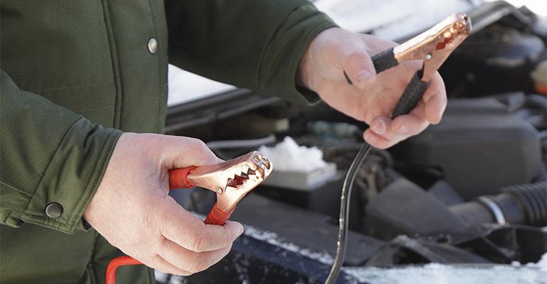 Mężczyzna trzymający kable rozruchowe
