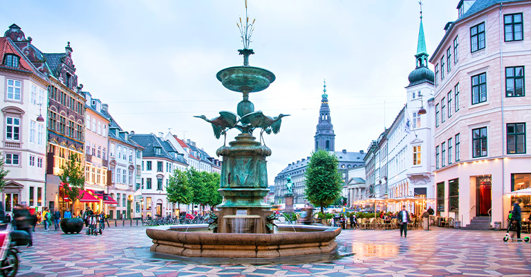Plac Gammeltorv w Kopenhadze z fontanną i otaczającą architekturą miejską. Zabytkowe centrum Kopenhagi.