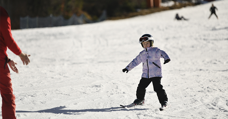 Dziecko uczące się jazdy na nartach