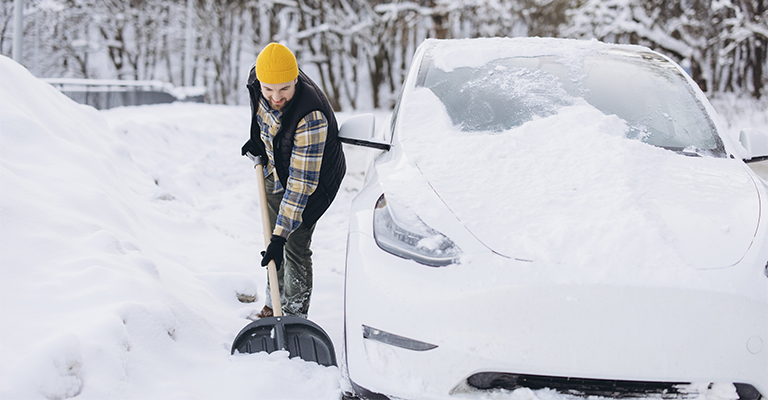 Człowiek odśnieżający samoch&oacute;d