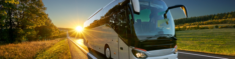 bus fährt durch landschaft bei sonnenuntergang