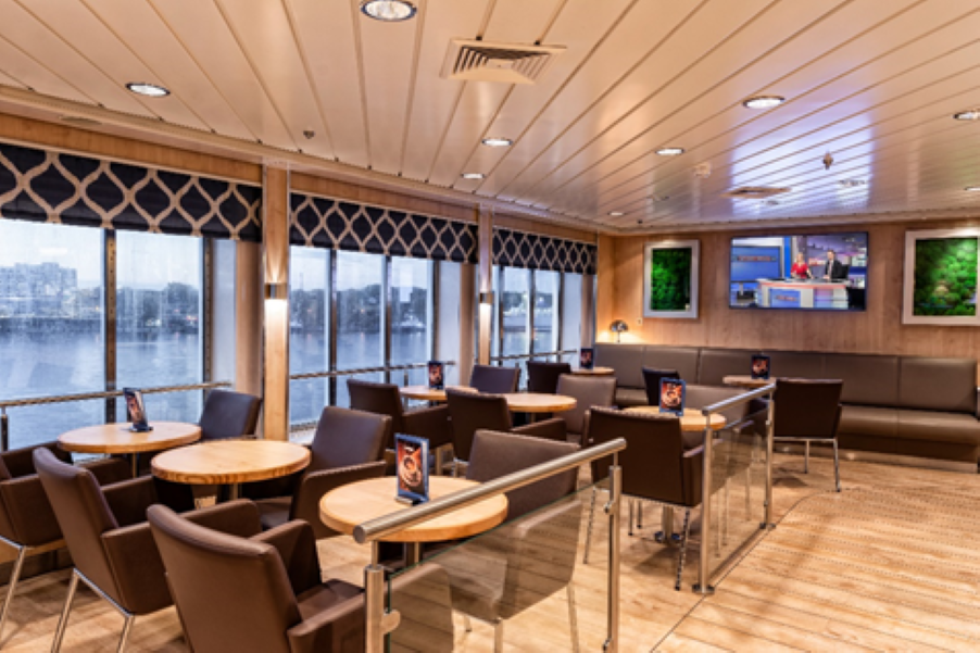 Lounge med TV och bekväma sittplatser för sport och nyheter ombord på TT-Line färja.