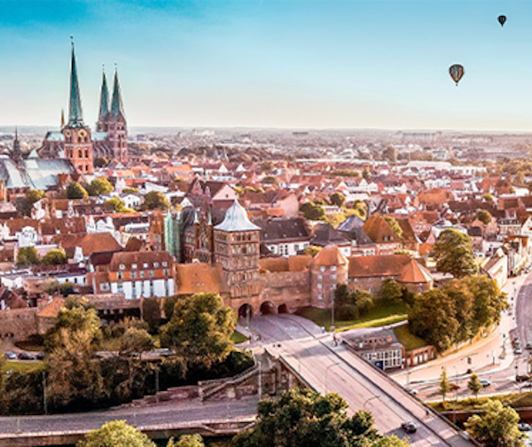 Luftbild över Lübecks gamla stad med Marienkirche och luftballong i bakgrunden.